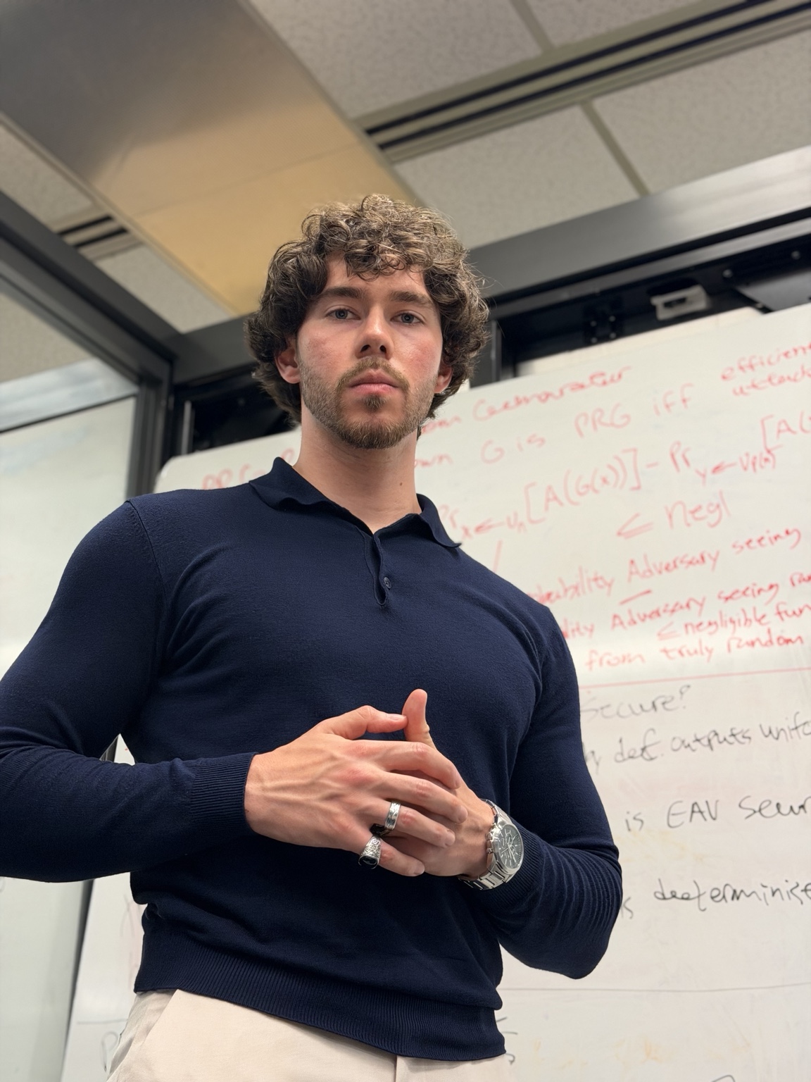 Murat Ismail Sen standing beside a whiteboard while working on cryptography concepts